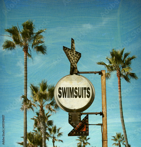 aged and worn vintage photo of swimsuit beach sign