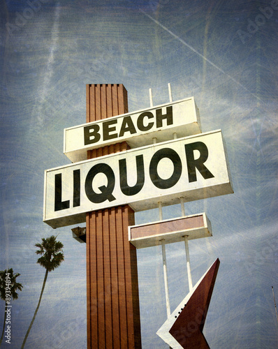 aged and worn vintage photo of liquor store sign with palm trees