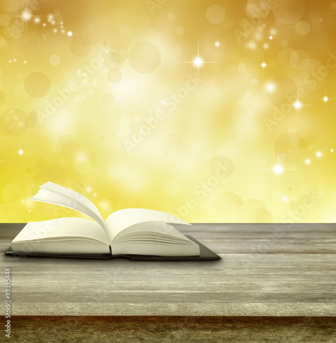 Book on table and blurred golden background