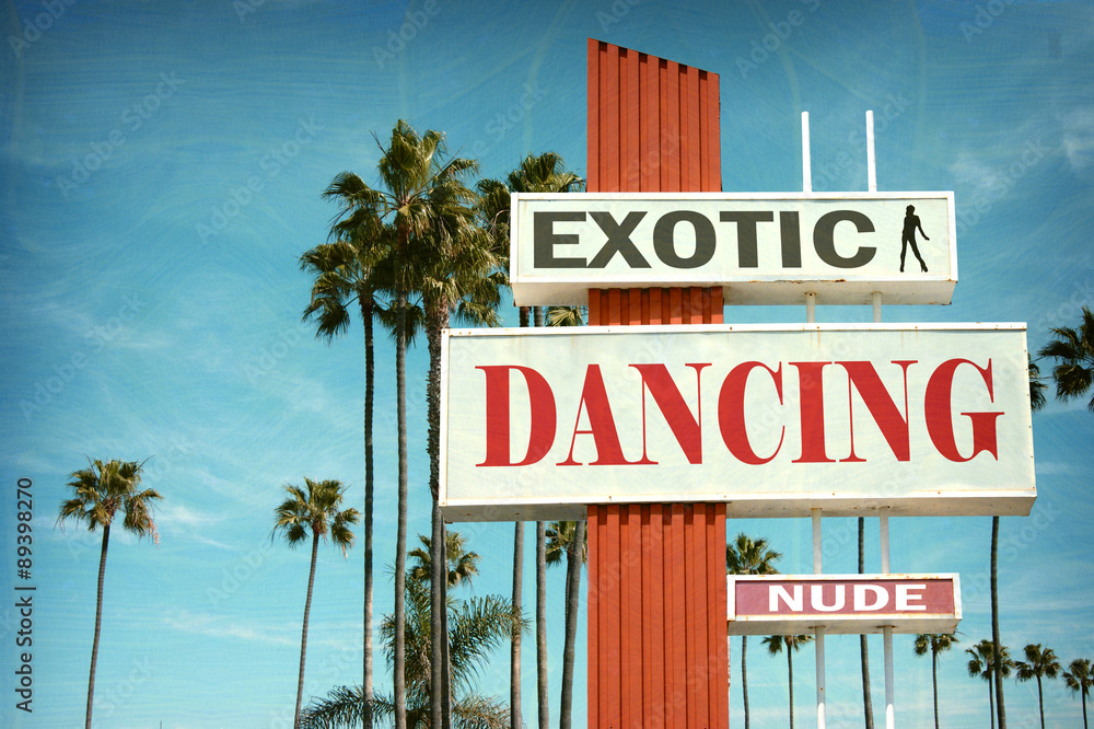 aged and worn vintage photo of exotic dancing sign with palm trees