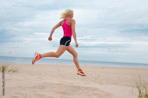 Jumping blond woman in summer sportswear.