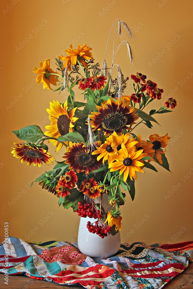 Obraz premium Still life with a bouquet of yellow and red flowers on a bright