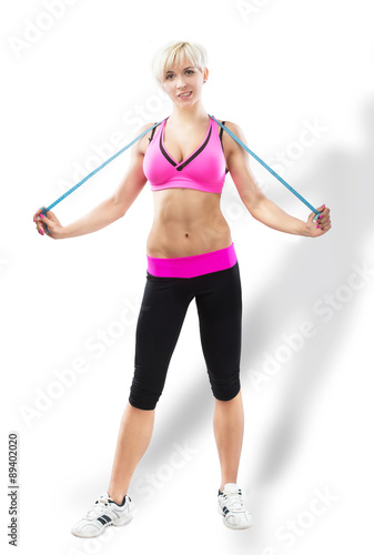 Sportive woman with the tape measure, studio shot, gray background