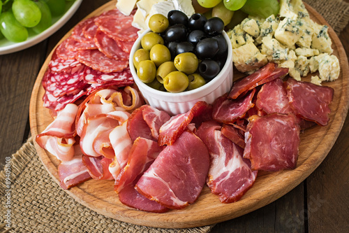 Antipasto catering platter with bacon, jerky, salami, cheese and grapes 