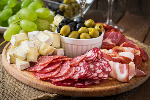 Antipasto catering platter with bacon, jerky, salami, cheese and grapes Fototapeta