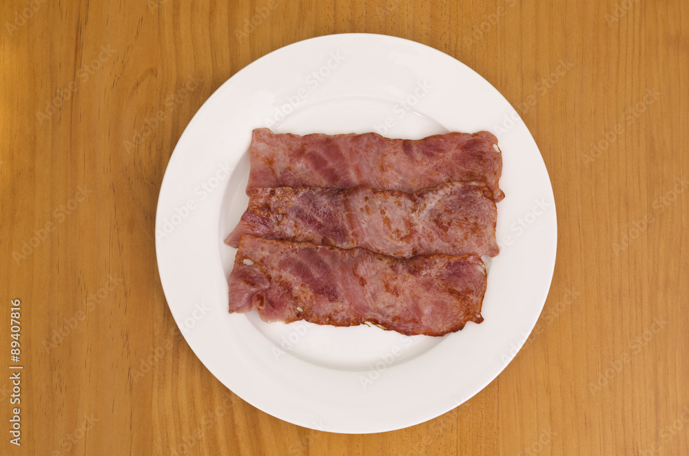 Fried bacon strips on plate Fried bacon strips on plate