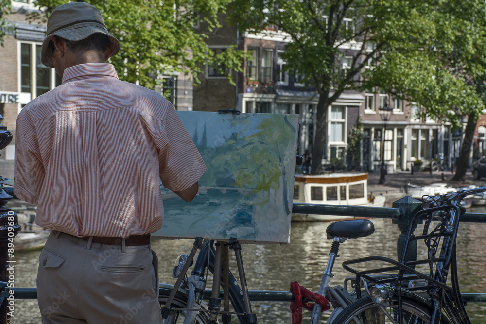 The artist paints a picture of the street near the canal in Amsterdam, Europe