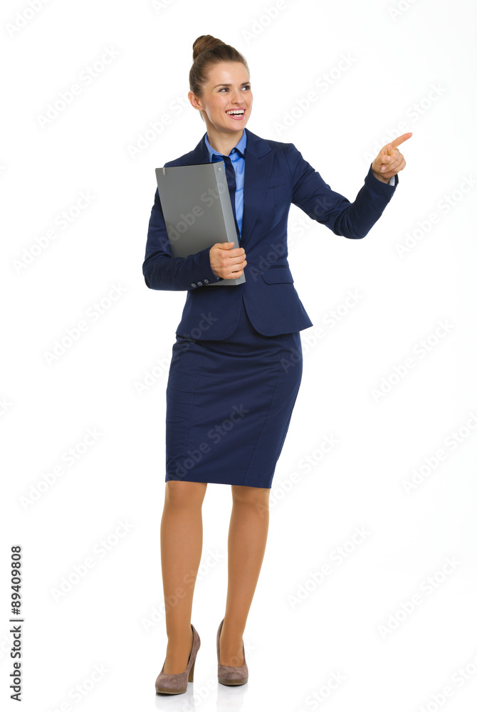 Smiling businesswoman holding file and pointing into distance Smiling businesswoman holding file and pointing into distance