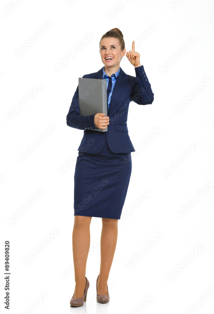 Smiling businesswoman holding file and pointing upwards Smiling businesswoman holding file and pointing upwards