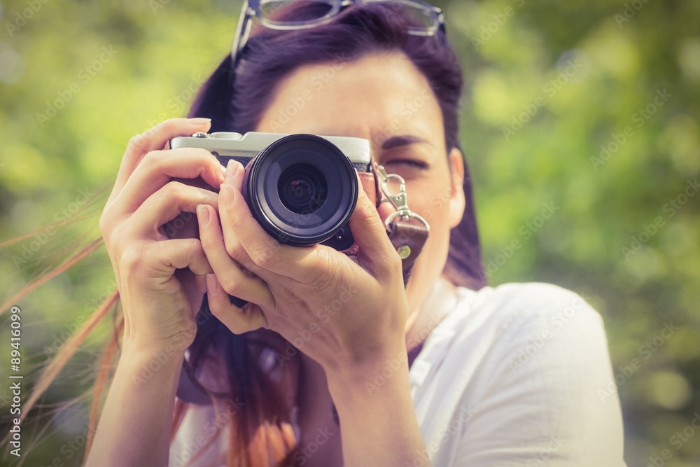 Beautiful brunette taking photo in the park Beautiful brunette taking photo in the park