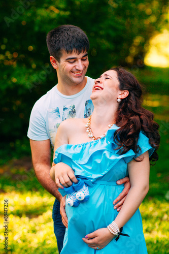 Beautiful pregnant couple relaxing outside in the park. © davit85