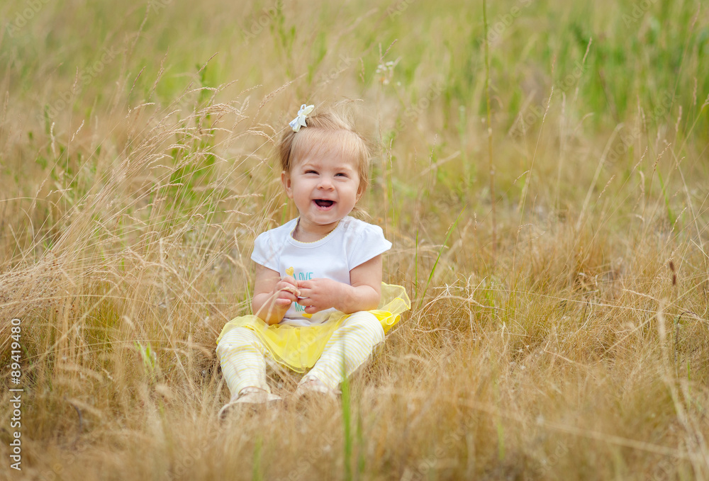 happy little girl sitting on the grass happy little girl sitting on the grass
