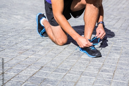 Athlete tying his shoes on a sunny day