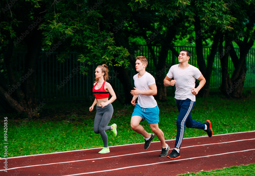 Obraz premium Running young people at stadium track