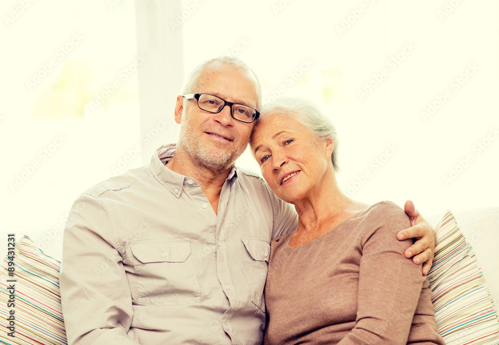 happy senior couple hugging on sofa at home happy senior couple hugging on sofa at home
