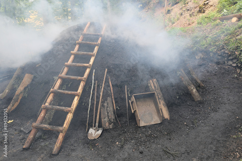 Rauchender Kohlenmeiler im Schwarzwald nach traditionellem Köhler - Handwerk aus  reinem Buchenholz hergestellt