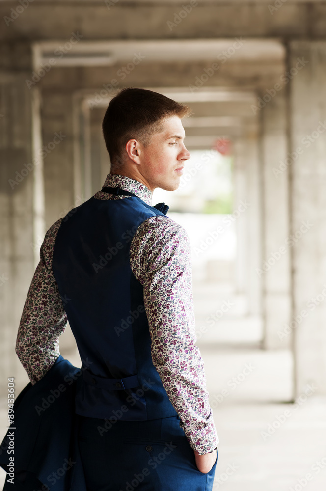 Rear view of a young handsome man in a flower shirt and vest