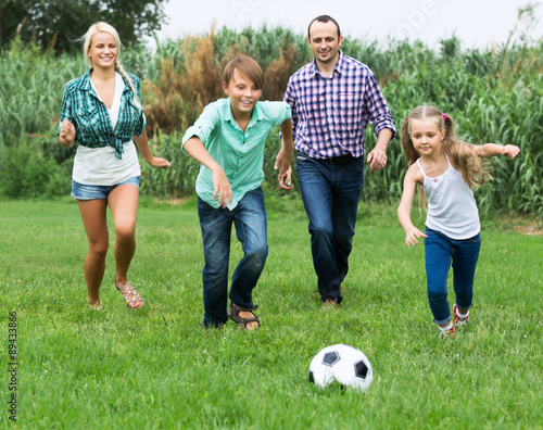Cheerful family running with ball