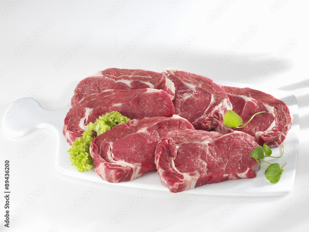 Entrecote steaks on ceramic chopping board Entrecote steaks on ceramic chopping board