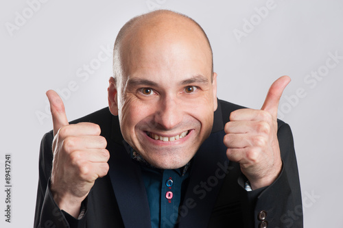 man making a silly face and giving thumb up photo