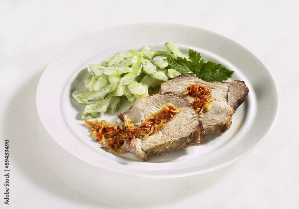 Slices of spit-roasted pork with cucumber salad Slices of spit-roasted pork with cucumber salad
