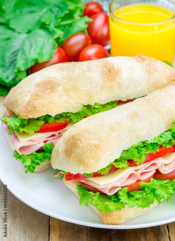 Healthy ciabatta bread sandwiches with ham and cheese on the white plate Healthy ciabatta bread sandwiches with ham and cheese on the white plate