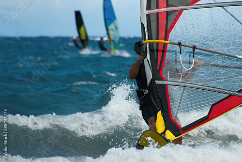 Three windsurfers in action