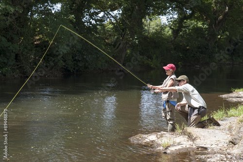 Fly fishing a gillie instructing a pupil on the River Lyd Devon UK photo
