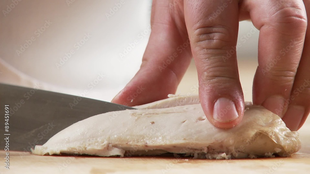 Cooked chicken breast being cut into small pieces Cooked chicken breast being cut into small pieces