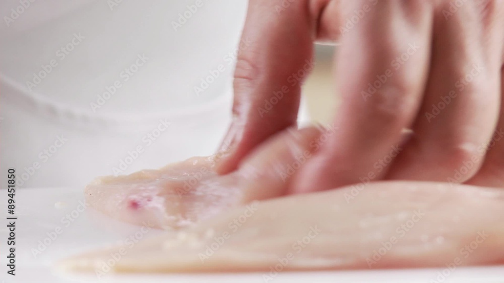 Fat and sinews being cut away from chicken breasts Fat and sinews being cut away from chicken breasts