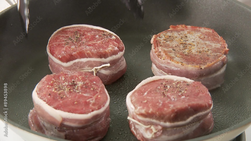 Beef fillet slices being fried on both sides Beef fillet slices being fried on both sides