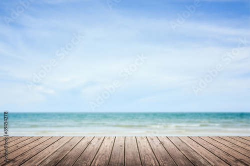 wooden floor with sea and sky blurred background