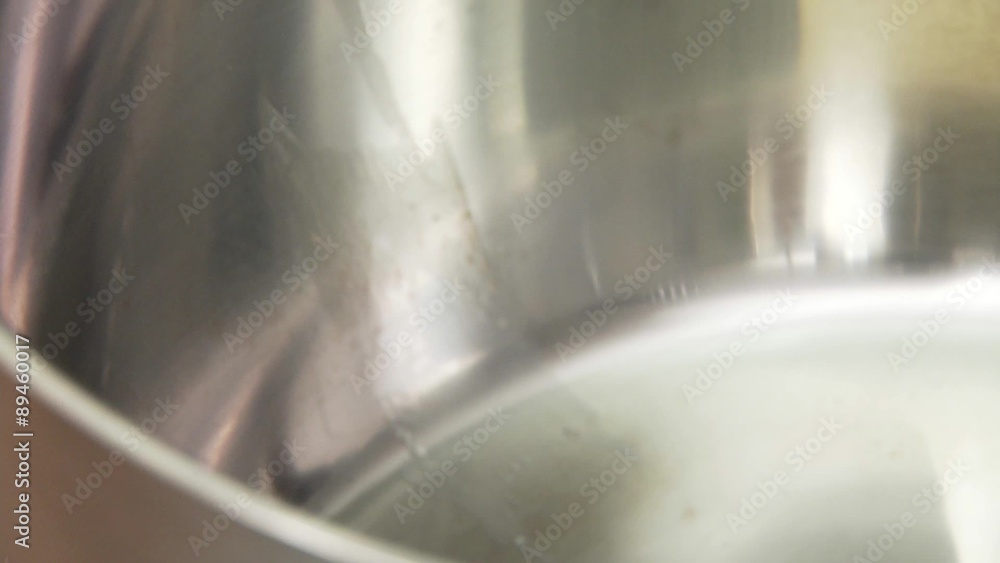 A piece of butter being put into a pan A piece of butter being put into a pan