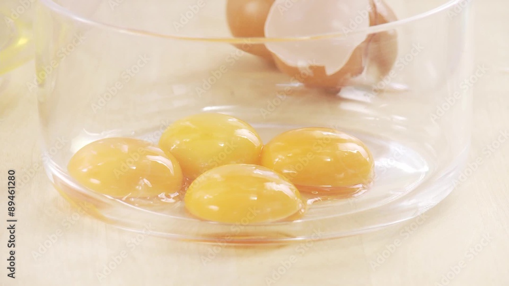Egg yolk being poured into a bowl Egg yolk being poured into a bowl