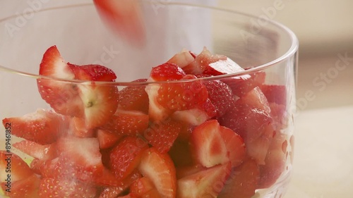 Strawberry pieces being put into a bowl