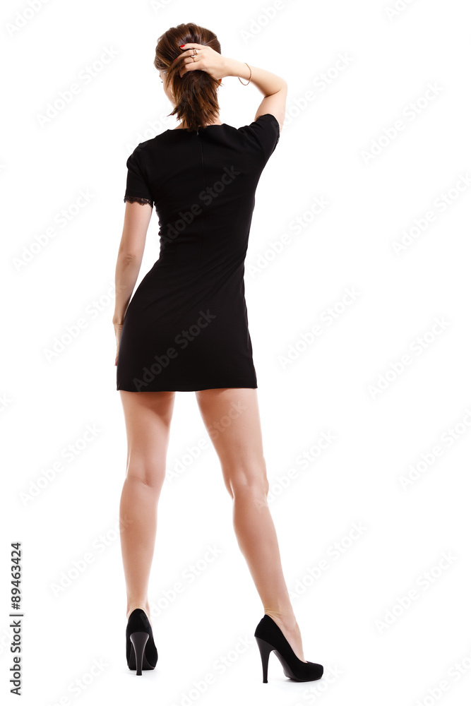 Fototapeta premium Young pretty woman in mini black dress isolated on white
