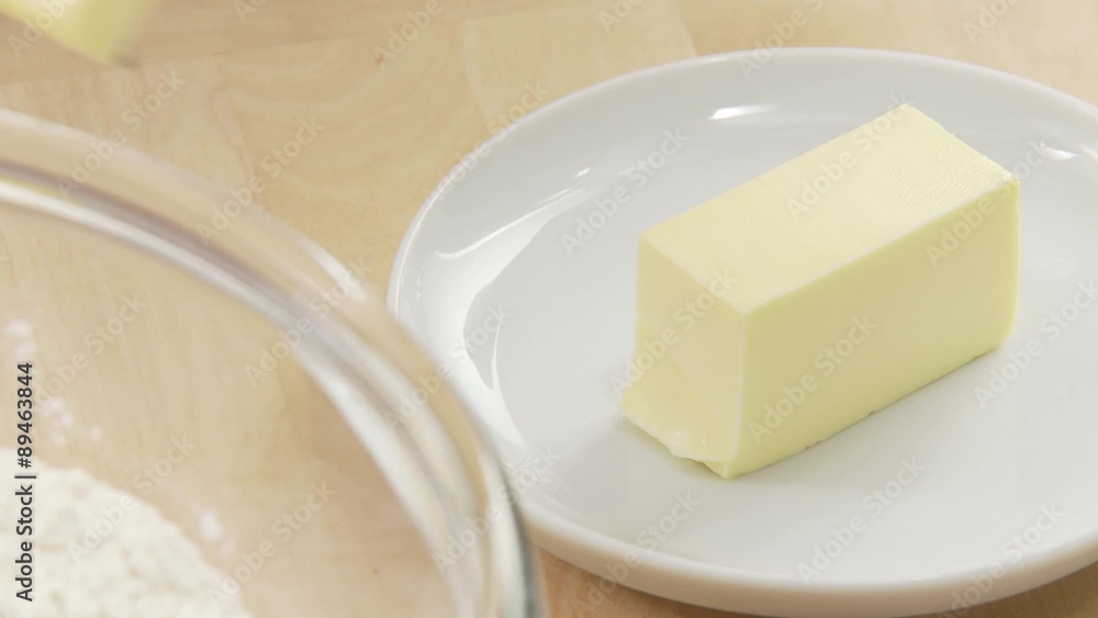 A piece of butter being chopped A piece of butter being chopped