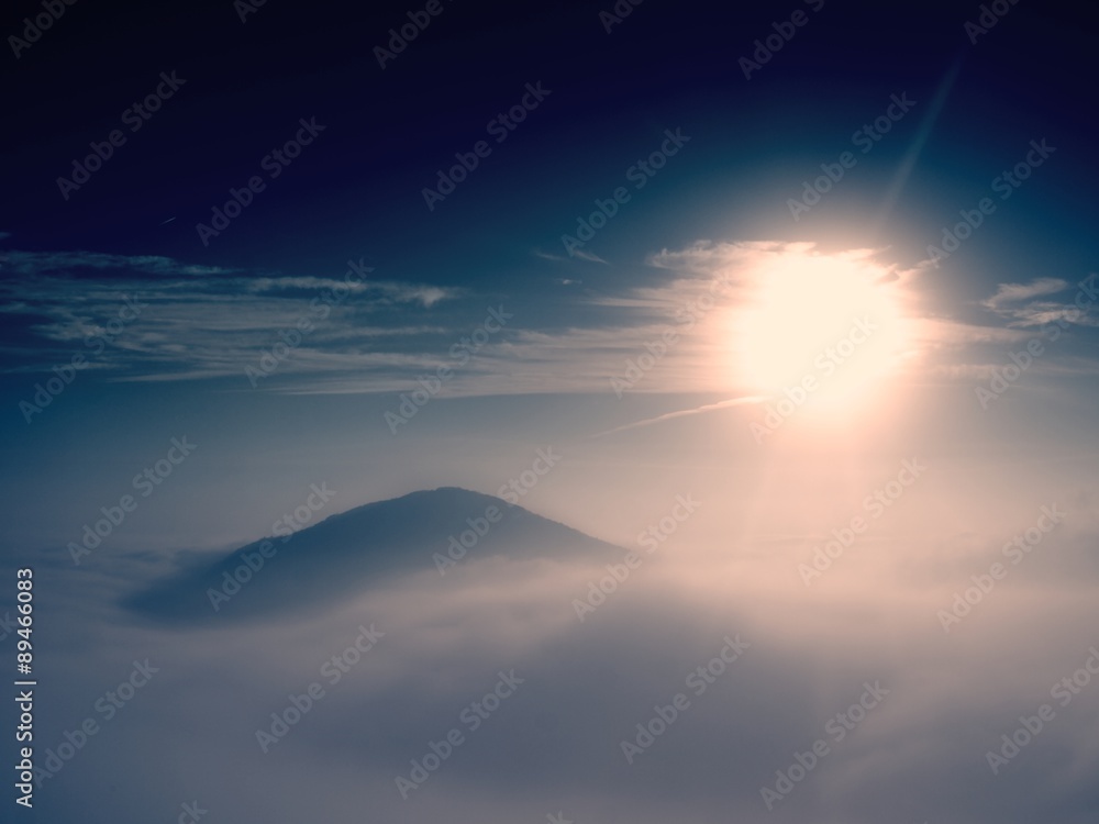 Magnificent heavy mist in landscape. Autumn fogy sunrise in a countryside. Hill increased from fog.