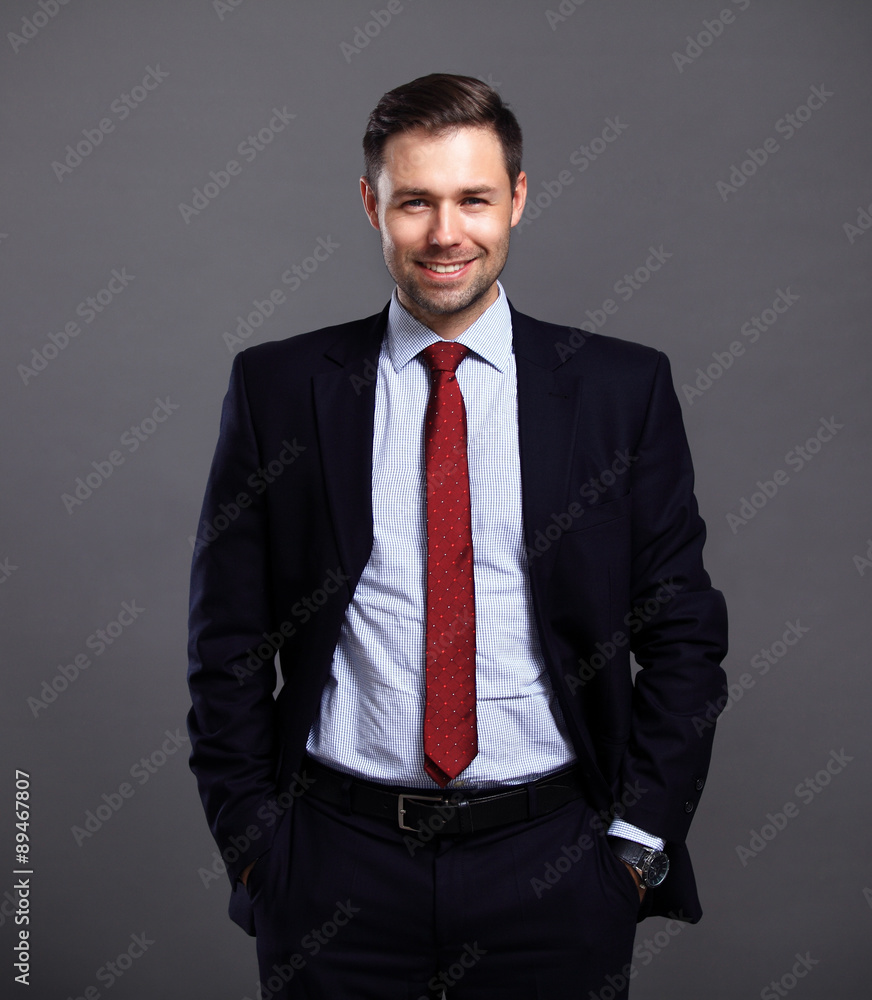 Cool businessman standing on grey background Cool businessman standing on grey background