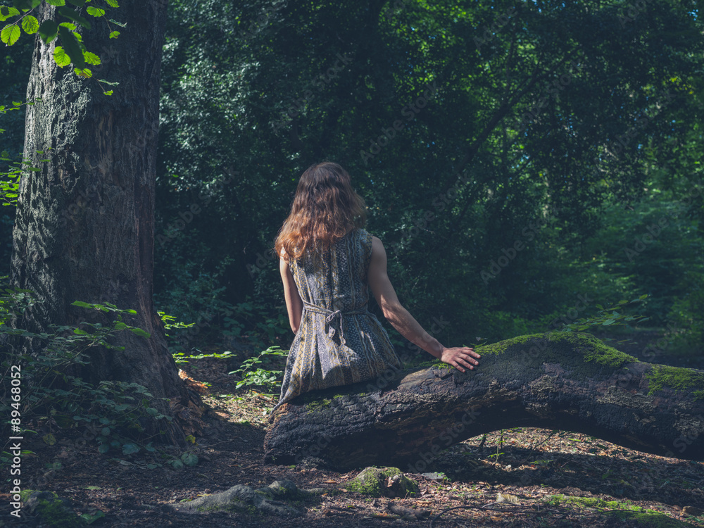 Woman sitting on log in forest Woman sitting on log in forest