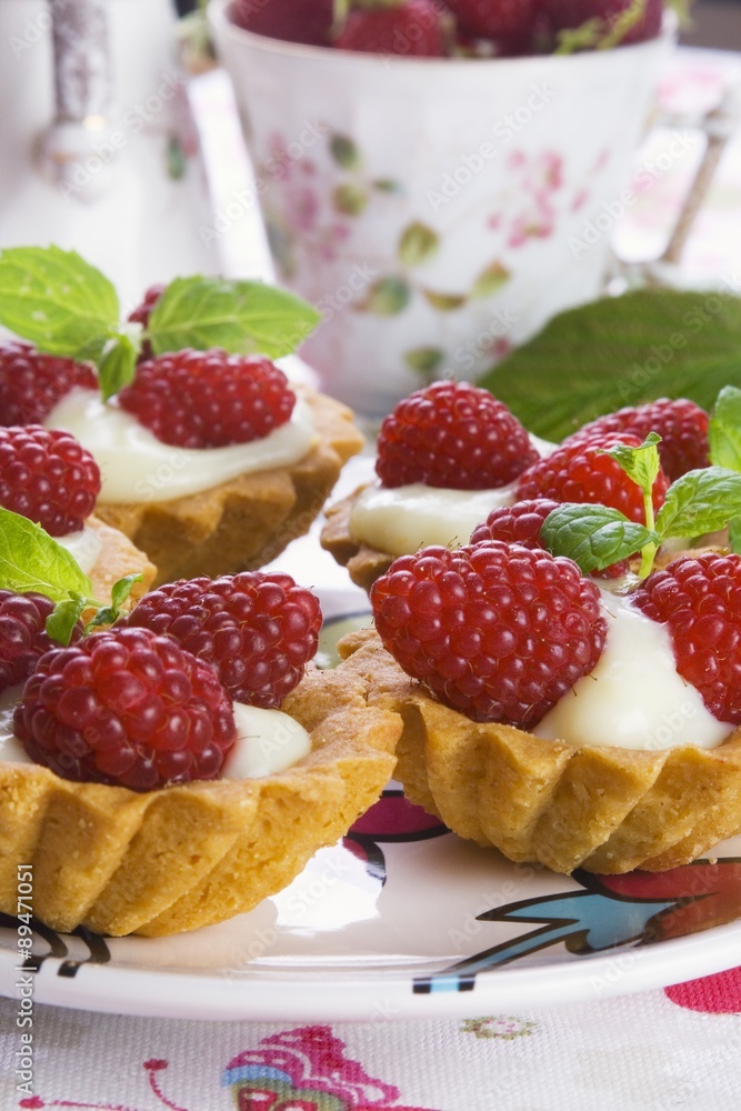 Tart shells filled with custard and fresh raspberries Tart shells filled with custard and fresh raspberries