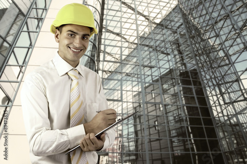 Young architect wearing a protective helmet standing on the buil © Andrii IURLOV