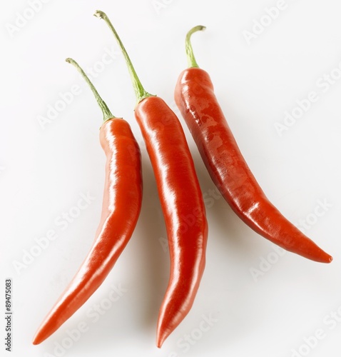 Three shiny red chillies