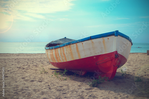 An abandoned deteriorated boat aground in the beach. Copy space for editor's text.