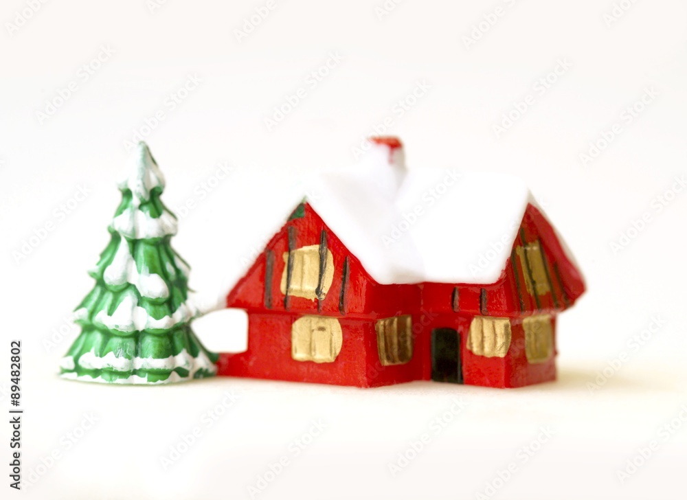 Christmas decorations: red house and snow-covered fir tree