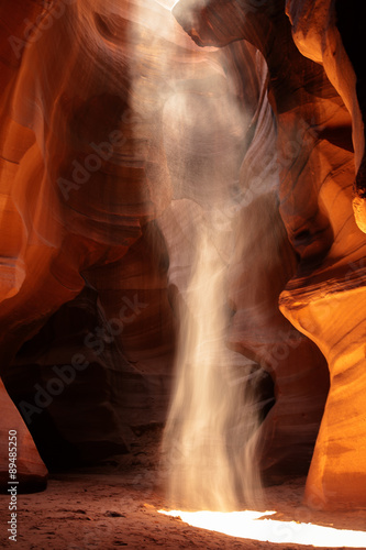 Sand falls in a light ray inside Antelope Canyon