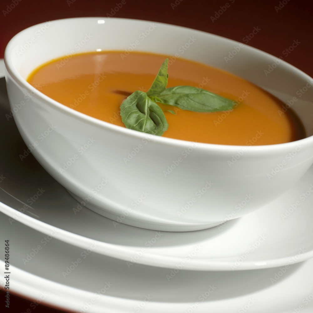 Tomato soup with basil in a soup bowl Tomato soup with basil in a soup bowl
