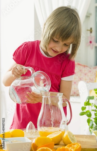 Girl making orange lemonade