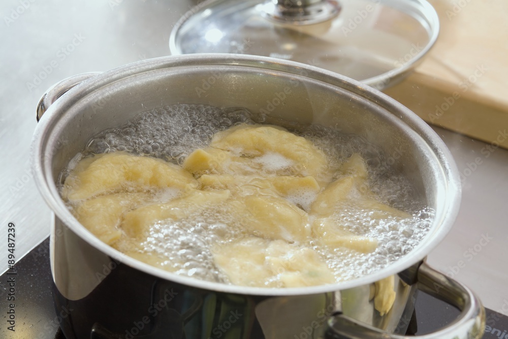 Cooking pierogi (savoury filled dumplings) in boiling water Cooking pierogi (savoury filled dumplings) in boiling water