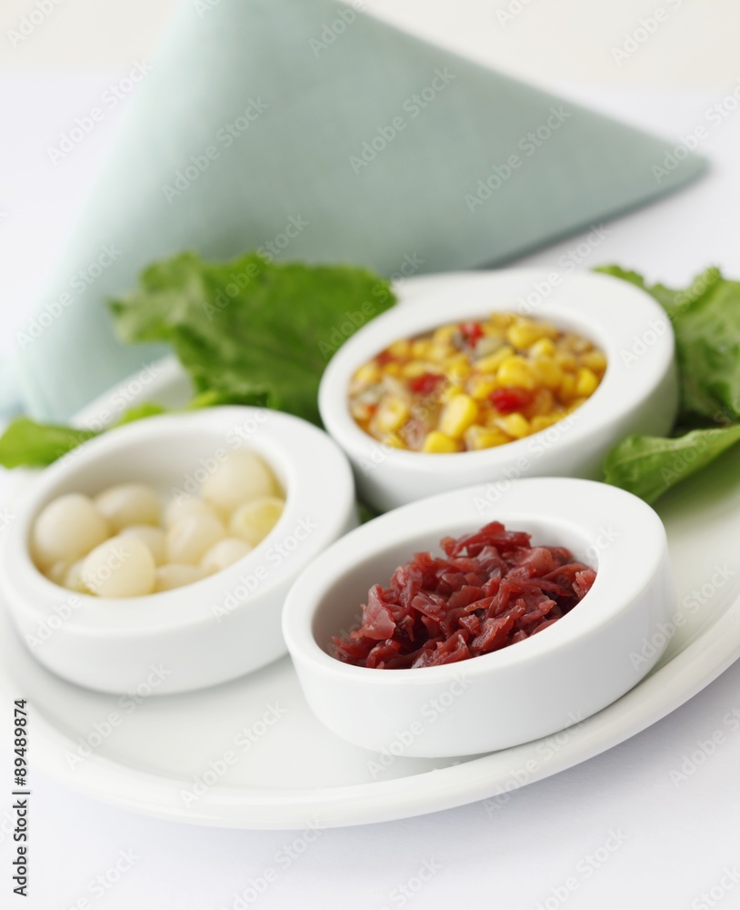Red Cabbage, Pearl Onions and Corn and Red Peppers in Small White Bowls on a Platter Red Cabbage, Pearl Onions and Corn and Red Peppers in Small White Bowls on a Platter